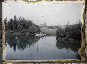 Image représentant Une pièce d'eau ou un canal avec la ville dominée par la Bad Kapel à l'arrière-plan