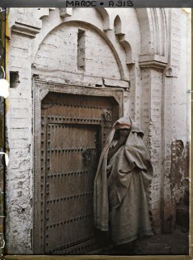 Image représentant Femme devant une porte cloutée
