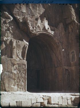 Image représentant La grande grotte, celle de Khosro II. Au-dessus de la voûte, figure ailée d'inspiration romaine portant l'anneau du pouvoir et le diadème royal