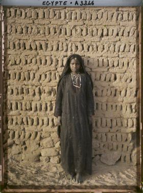 Image représentant Jeune fille berbère posant devant un mur en  null pisé