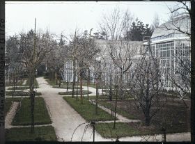 Image représentant Partie est du verger-roseraie en début de printemps, traversée par une allée menant à la forêt bleue