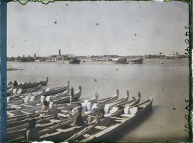 Image représentant La ville, vue sur la rive gauche du Chatt al 'Arab ; au premier plan, des bateaux "Belems"