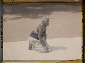 Image représentant La gardienne des trônes (l'ancienne amazone de Glélé Djébénou) dans la cour du palais de  null Guézo (jalalahennou)