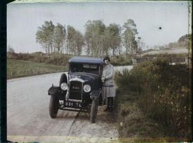 Image représentant Madame Misme pose à côté de sa voiture, un modèle Peugeot type 190 torpedo, sur la route de Jumilhac