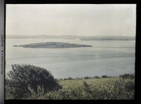 Image représentant L'îlot d'Er Lannic où l'on distingue plusieurs menhirs des cromlechs, vue prise depuis le tumulus de Gavrinis