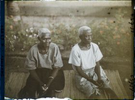Image représentant Deux femmes âgées assises sur une natte de paille, assistant probablement à un cours sur le christianisme