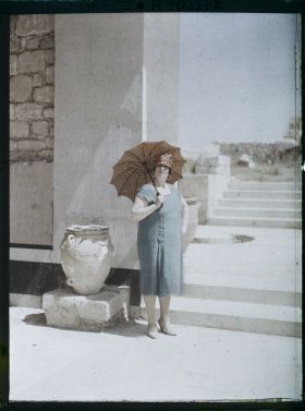 Image représentant Femme d'une quarantaine d'années élégamment vêtue au pied des Propylées sud (guide, interprète, compagne de l'opérateur ?)