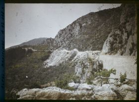Image représentant Route dans un paysage rocheux avec pieds de vigne au premier plan