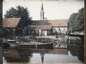 Image représentant Vue d'un canal dans le village, à l'arrière-plan la tour de l'Horloge