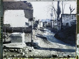 Image représentant Une rue bordée de bâtiments en ruines, dont une mosquée (quartier de Suk-Kuyu)