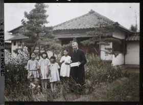 Image représentant Le père Cesselin, missionnaire français, entouré d'un groupe d'enfants vêtus à l'occidentale