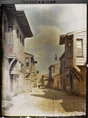 Image représentant Une rue pavée bordée de maisons construites en pierre au rez-de-chaussée avec une élévation en bois