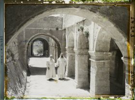 Image représentant Monseigneur Berré avec un moine dominicain dans le cloître du couvent