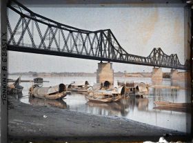 Image représentant Le pont Doumer et les sampans bordant les quais du Fleuve Rouge, le matin