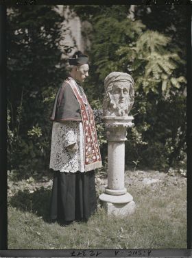 Image représentant Monseigneur Landais, archiprêtre de la cathédrale posant près d'une statue