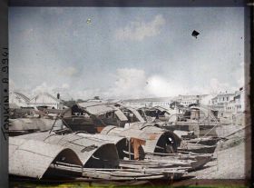 Image représentant Des sampans amarrés aux quais, devant des entrepôts et des habitations