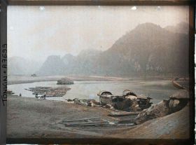 Image représentant Des sampans amarrés, juste en aval du barrage de rochers entravant le cours de la rivière Noire