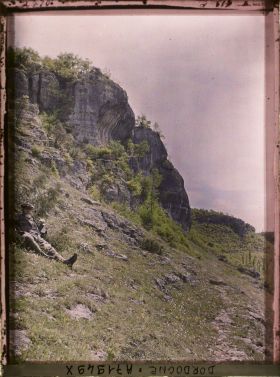 Image représentant Jean Brunhes dans l'herbe près de la grotte de Fond-de-Gaume