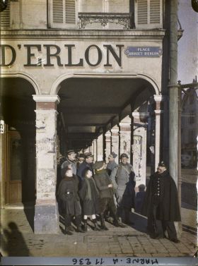 Image représentant Soldats et habitants sous les arcades de la place Drouet d'Erlon pendant le passage d'un avion