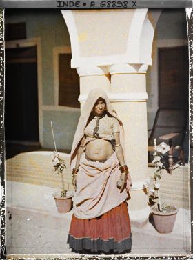 Image représentant Une femme debout à l'entrée d'une maison ou dans une cour intérieure