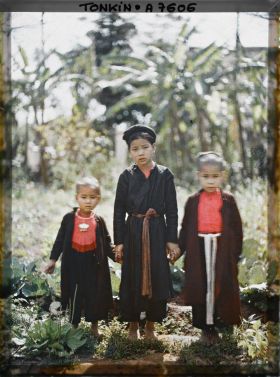 Image représentant Une jeune fille en turban tenant par la main deux enfants de moins de douze ans