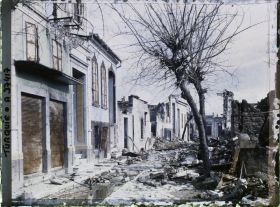 Image représentant Rue bordée de bâtiments endommagés (Rue Mazi)