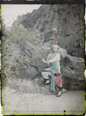 Image représentant Une actrice du Théâtre saïgonnais posant devant un rocher