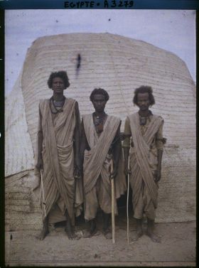 Image représentant Trois hommes  null bishari posant devant une habitation