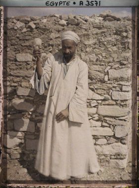 Image représentant Un homme filant la laine pose pour l'opérateur