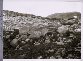 Image représentant L'aide de Wilse assis dans les éboulis près du glacier