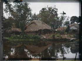 Image représentant Des maisons au bord d'une mare, dans un village