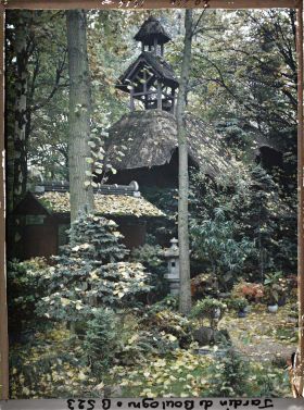 Image représentant Porte du " village japonais " ouvrant sur le jardin anglais, sous une pluie de feuilles automnale