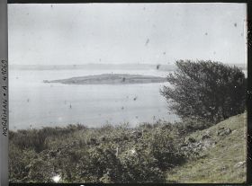 Image représentant L'îlot d'Er Lannic où l'on distingue plusieurs menhirs des cromlechs, vue prise de l'île de Gavrinis