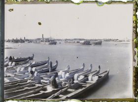 Image représentant La ville, vue sur la rive gauche du Chatt al 'Arab ; au premier plan, des bateaux Belems