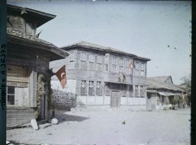 Image représentant Types de maisons à un étage en bois et en pierre, décorées de drapeaux turcs et de feuillages