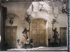 Image représentant Dans le vestibule du château, porte d'entrée principale du salon rouge au chiffre de Louis-Joseph, duc de Vendôme et encadrée par deux statues de bois portant des lanternes