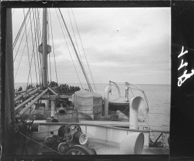 Image représentant Passagers sur pont supérieur vers l'avant du navire, au loin la côte américaine