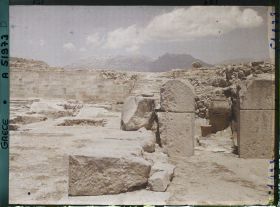 Image représentant Le palais. Dans la cour occidentale, au fond, l'escalier nord. En premier plan, à droite, extrémité des magasins avec un phitos (jarre)