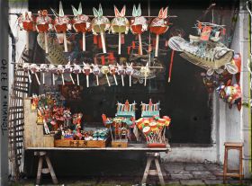 Image représentant Un étalage de jouets en papier huilé devant une boutique, dans la " rue du Chanvre "