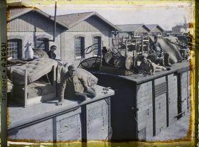 Image représentant Grecs quittant la ville sur le toit d'un train chargé de mobilier, de matellas et d'objets divers