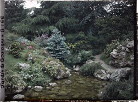 Image représentant Cours d'eau du " sanctuaire japonais " entre une rive fleurie et un chemin bordé de roches
