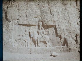 Image représentant Bas-relief sassanide sous le tombeau de Darius. Scène de triomphe de Shapur 1er sur Philippe L'Arabe, agenouillé et sur l'empereur romain Valérien qui remet ses armes au vainqueur monté sur son cheval (fin IIIe siècle)