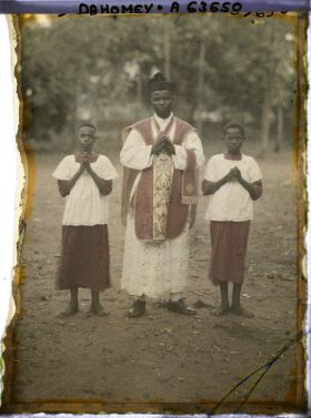 Image représentant L'abbé Gabriel Kiti, premier prêtre dahoméen ordonné par Mgr Steinmetz (le 15 septembre 1929) entouré de deux enfants de chœur