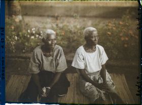 Image représentant Deux femmes âgées assises sur une natte de paille, assistant probablement à un cours sur le christianisme