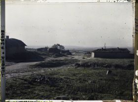 Image représentant Vue vers la plaine de Çorlu, avec des bâtiments le long d'une route de terre (probablement des fermes) ; de droite à gauche, une ligne électrique traverse le paysage