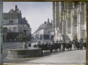 Image représentant Groupe d'enfants posant à côté de la fontaine et de l'église, place de la République