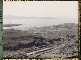 Image représentant Panorama vers les ruines de la ville antique (haute et basse) et la mer depuis l'Antre du Cinthe sur le versant occidental du mont Cinthe (au fond, l'Ile de Syros)