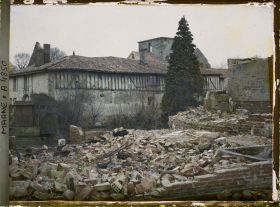 Image représentant Ruine d'une maison, au fond une maison en torchis et l'église Notre-Dame de la Nativité