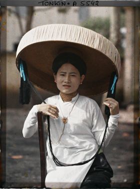 Image représentant Une jeune femme quarteronne portant le grand chapeau en feuilles de latanier muni d'une longue jugulaire ornée de pompons