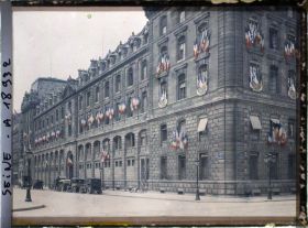 Image représentant La préfecture de police à l'angle de la rue de la Cité et du quai du marché neuf, décorée de drapeaux pour les fêtes de la Victoire des 13 et 14 juillet 1919